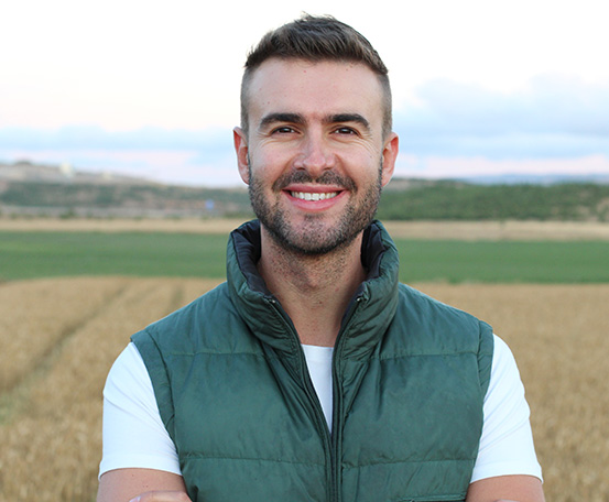 Farmer in a field wearing a vest.
